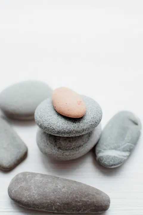 Piedras lisas grises y una rosa, apiladas